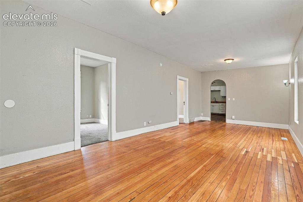 Image 16 of 34: Hardwood flooring, arched doorway, recessed wall sconces, ceiling-mounted l