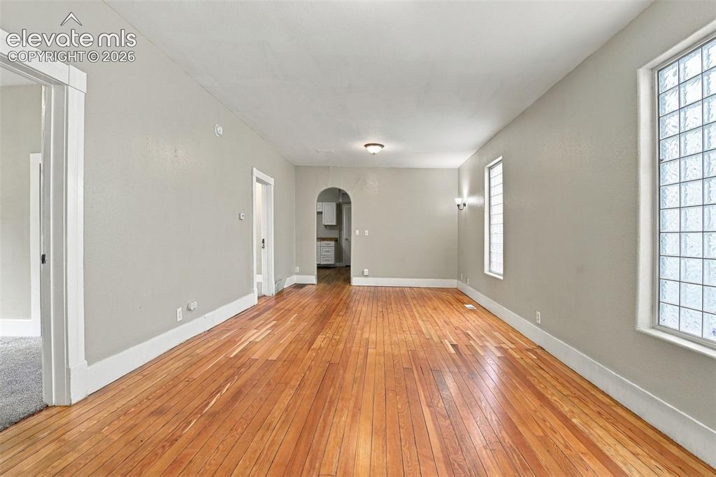 Image 17 of 34: Hardwood flooring, arched doorway, recessed lighting, and glass block windo