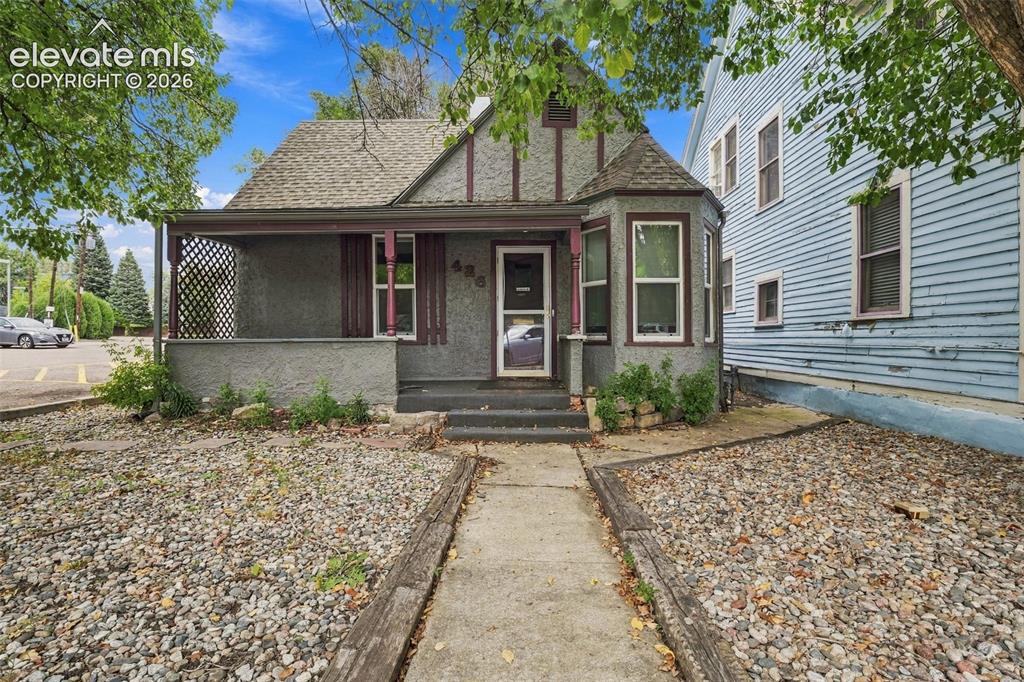 Image 2 of 34: Covered front porch, bay window, concrete walkway, gravel landscaping, and 