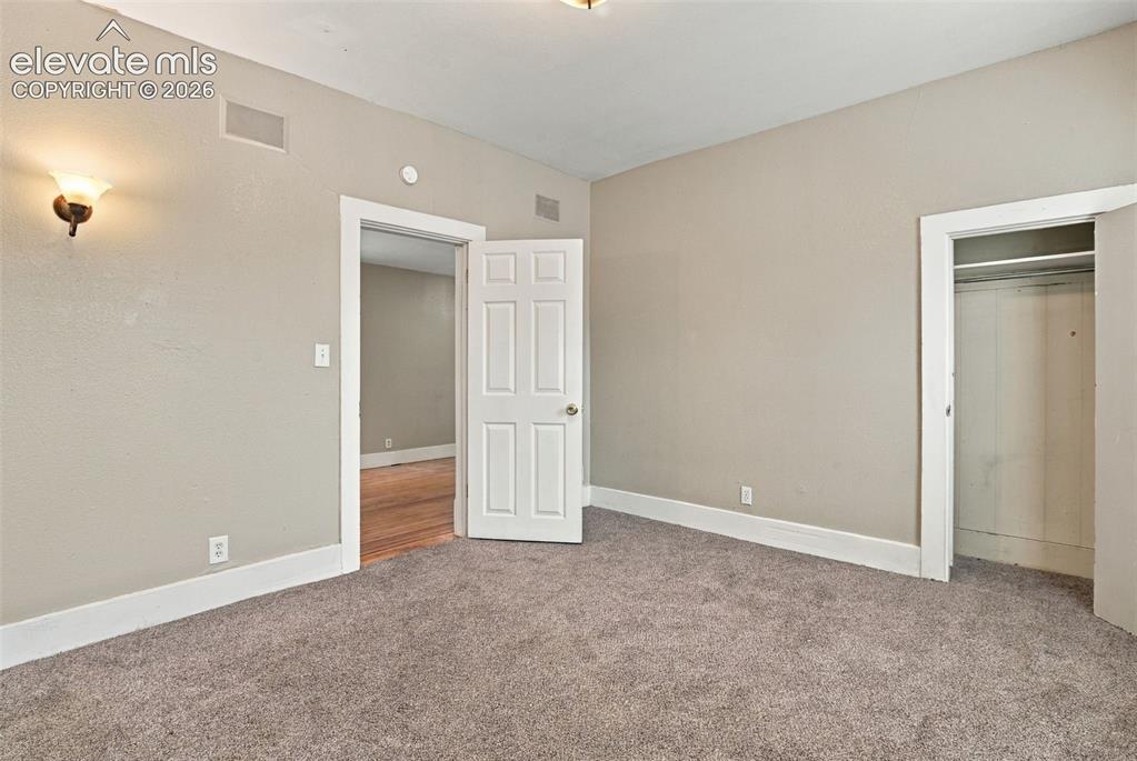 Image 20 of 34: Plush carpet flooring, neutral wall tones, white trim, and a built-in close