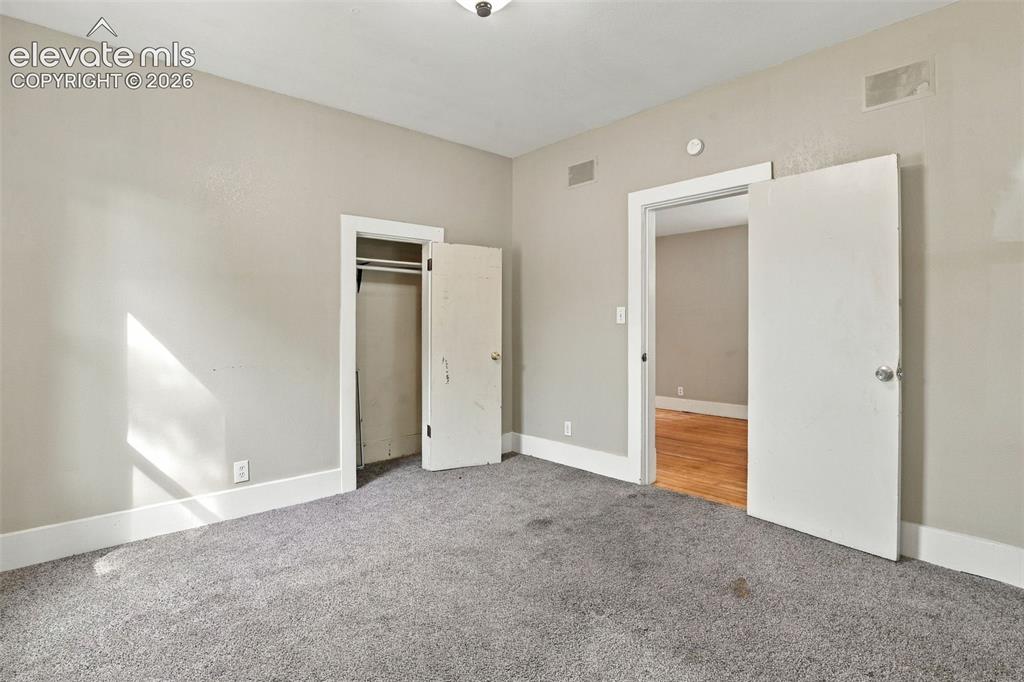Image 22 of 34: Neutral wall paint, gray carpet flooring, white trim, and a built-in closet