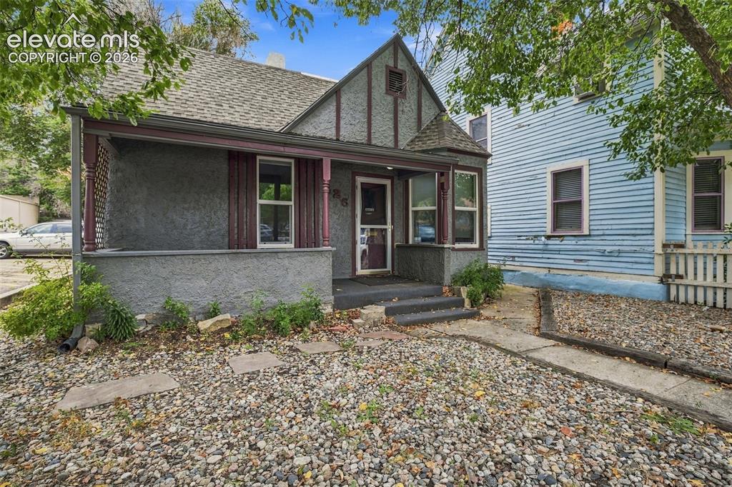 Image 31 of 34: Gable roofline with decorative trim, stucco exterior finish, covered front