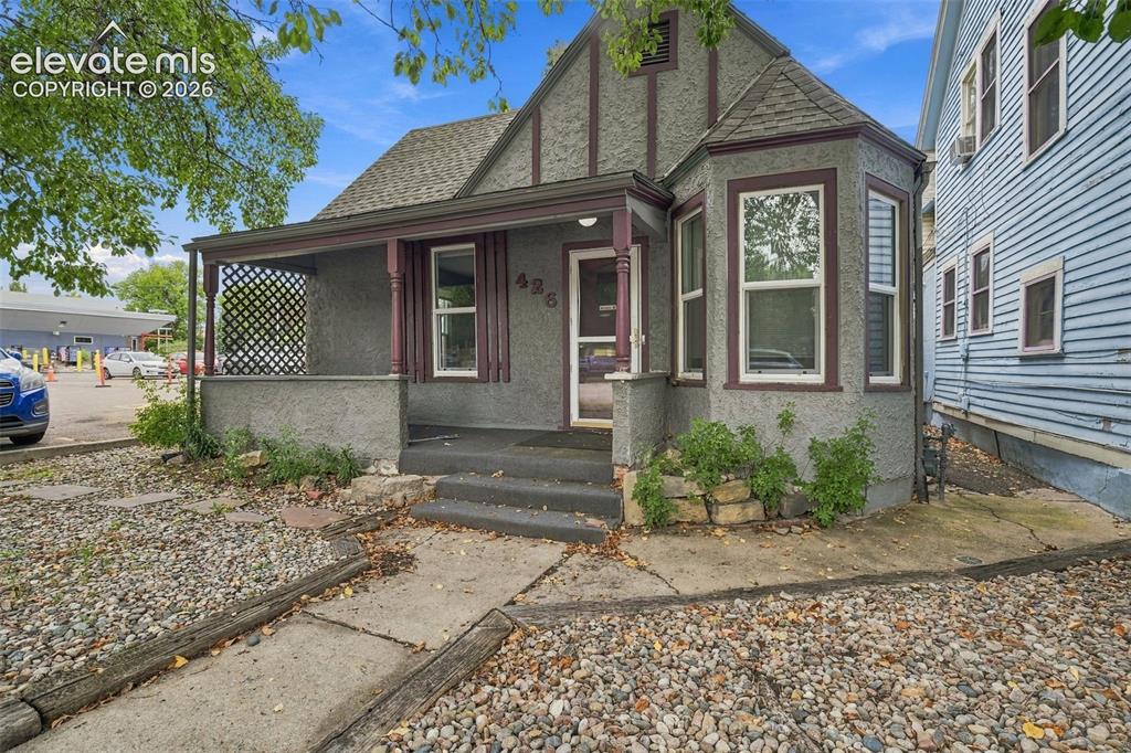 Image 32 of 34: Stucco exterior with contrasting trim, covered front porch, bay window feat
