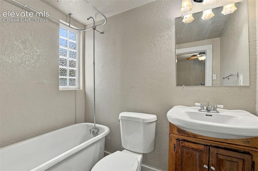 Image 4 of 34: Clawfoot tub with an overhead shower fixture, frosted glass window, single 