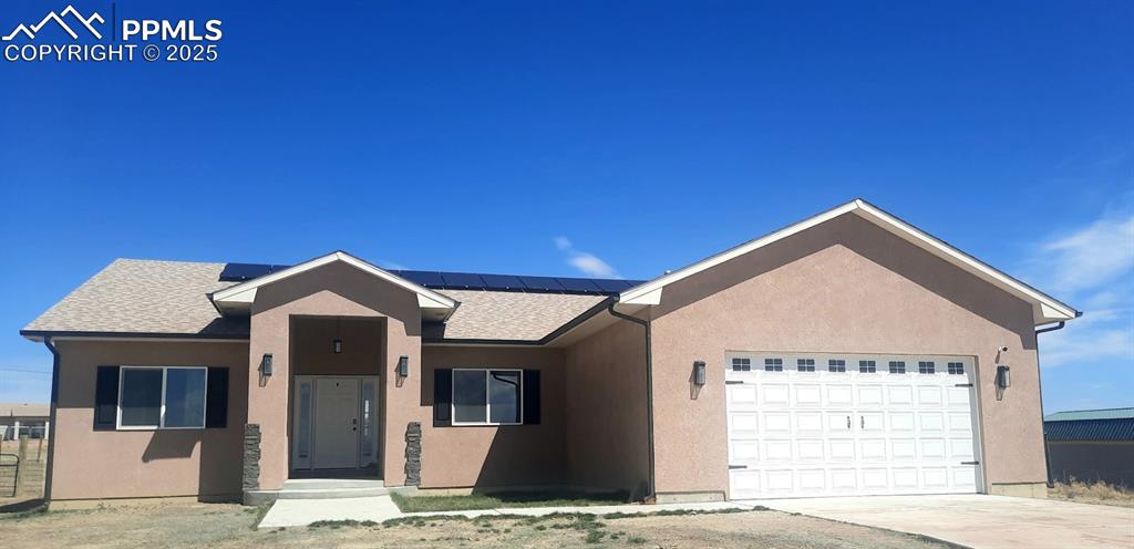 Caption: Ranch-style home featuring a shingled roof, concrete driveway, and stucco siding