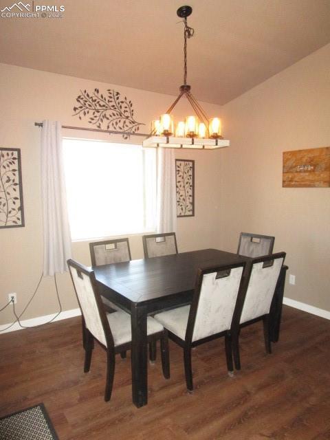 Image 3 of 6: Dining area featuring a chandelier and dark wood-style floors