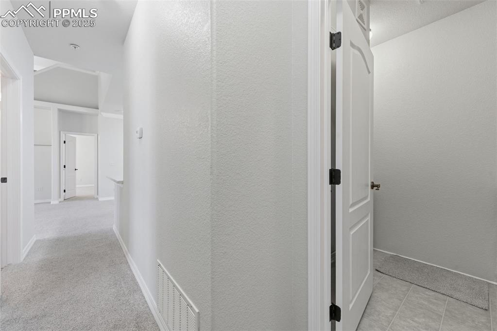 Image 16 of 39: Corridor with baseboards and a textured wall