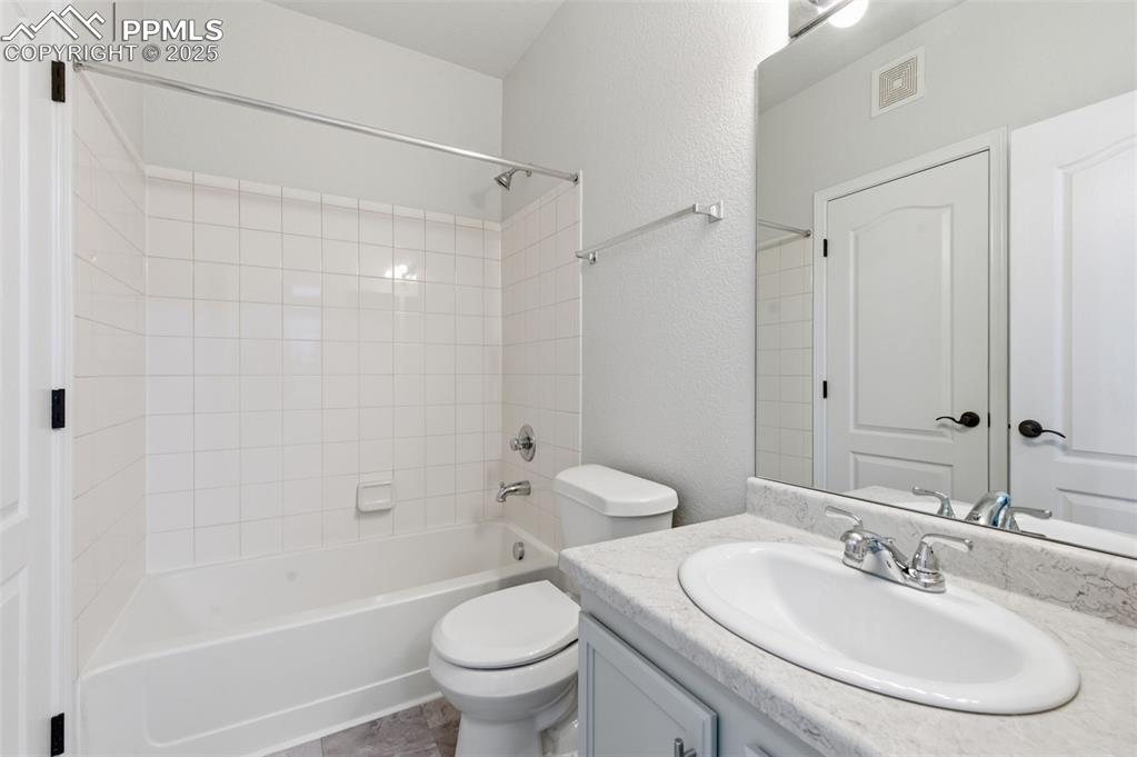 Image 19 of 39: Full bath with shower / tub combination, vanity, and a textured wall