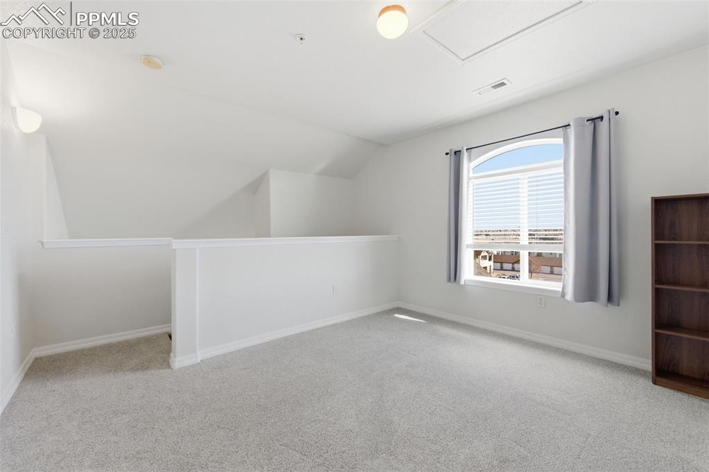 Image 30 of 39: Bonus room with light carpet and lofted ceiling