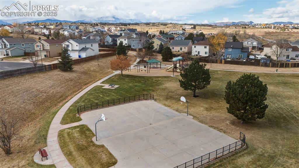 Image 37 of 39: Aerial view of residential area featuring a mountain backdrop and a communi
