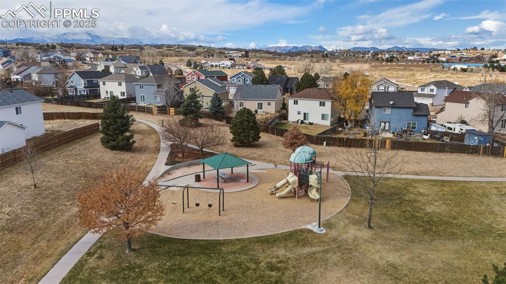 Image 38 of 39: Aerial perspective of suburban area featuring mountains and a recreational