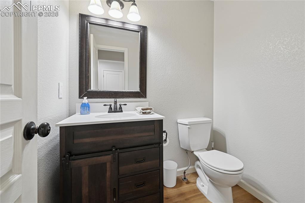 Image 14 of 37: Bathroom featuring vanity, light wood-style flooring, and a textured wall