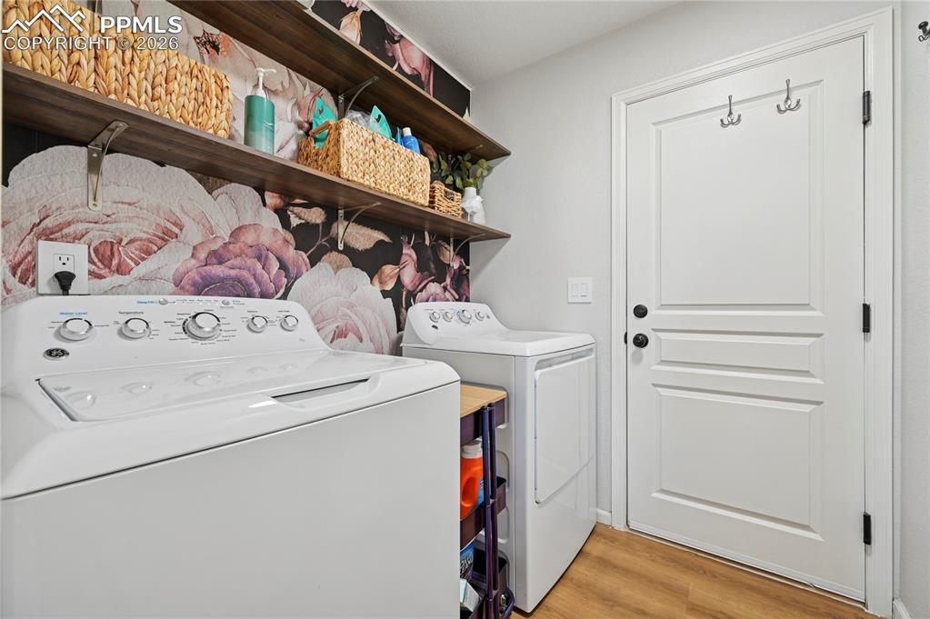 Image 15 of 37: Washroom with light wood-style flooring and washing machine and clothes dry