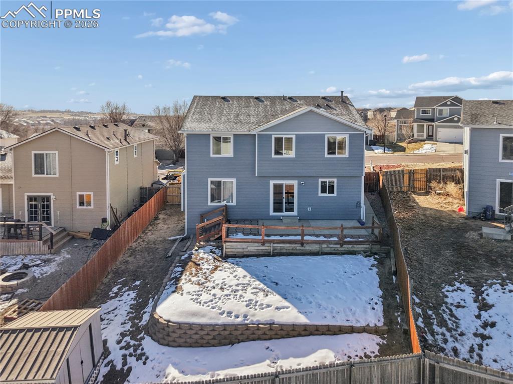 Image 32 of 37: Snow covered house featuring a residential view, a deck, and a fenced backy