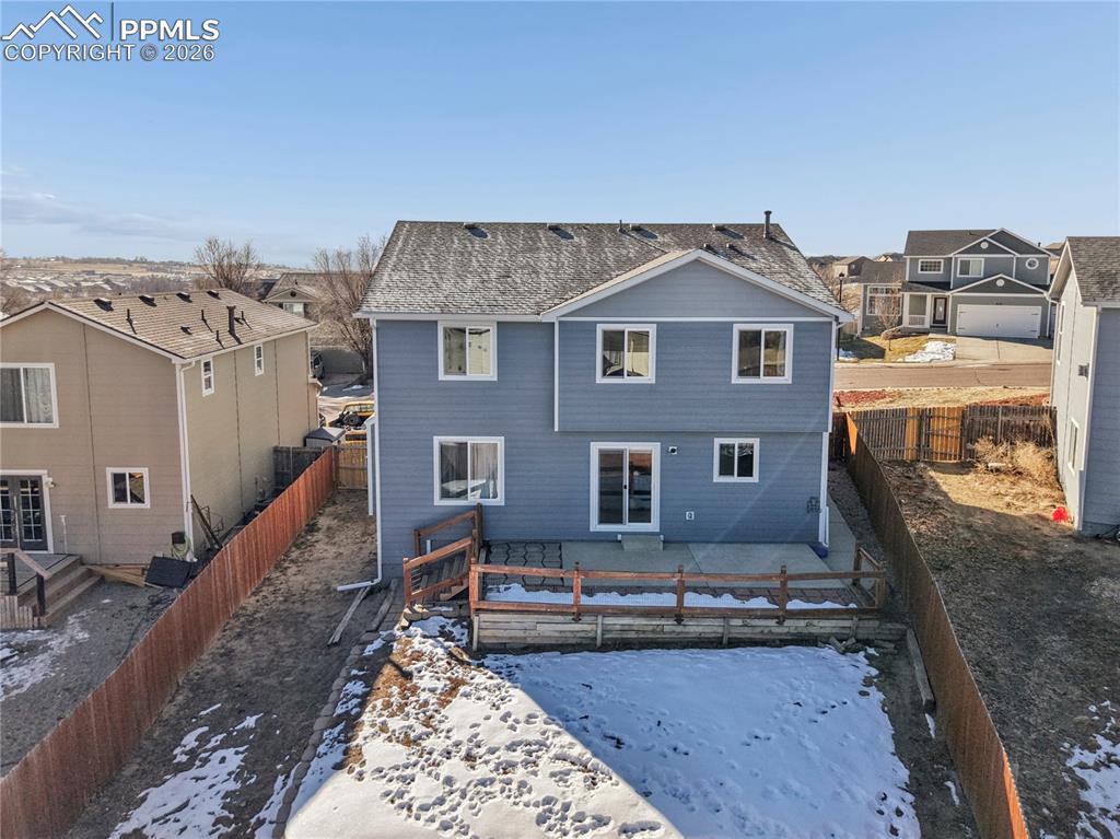 Image 33 of 37: Snow covered house featuring a residential view and a fenced backyard