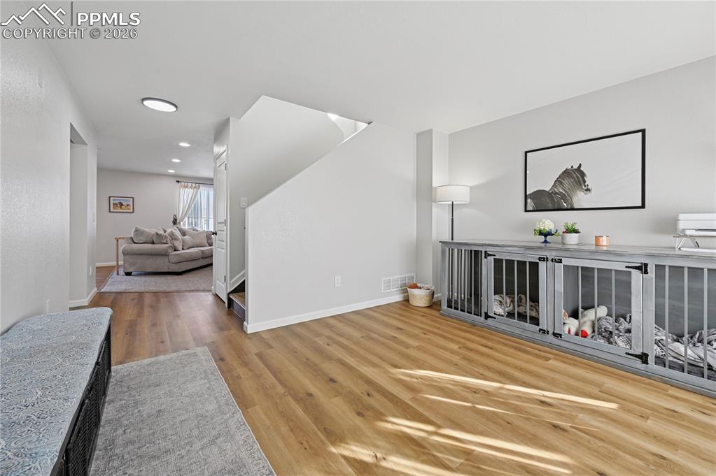 Image 6 of 37: Living room with light wood finished floors and recessed lighting