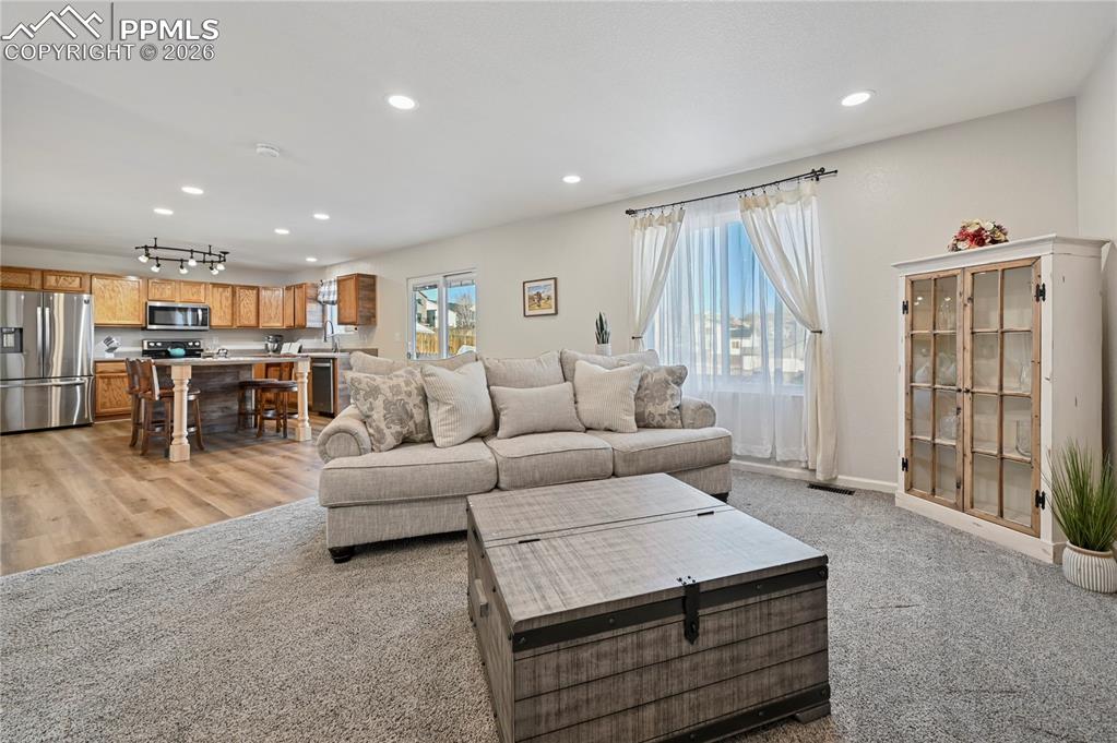 Image 7 of 37: Living room featuring light colored carpet, healthy amount of natural light