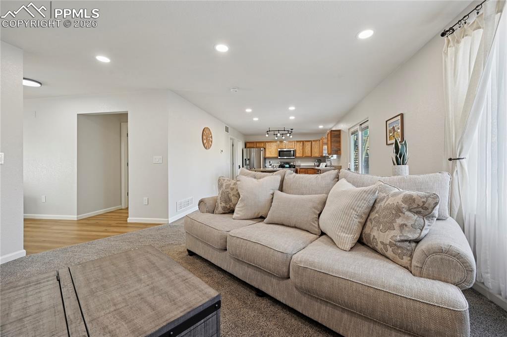 Image 9 of 37: Living room with recessed lighting and carpet flooring