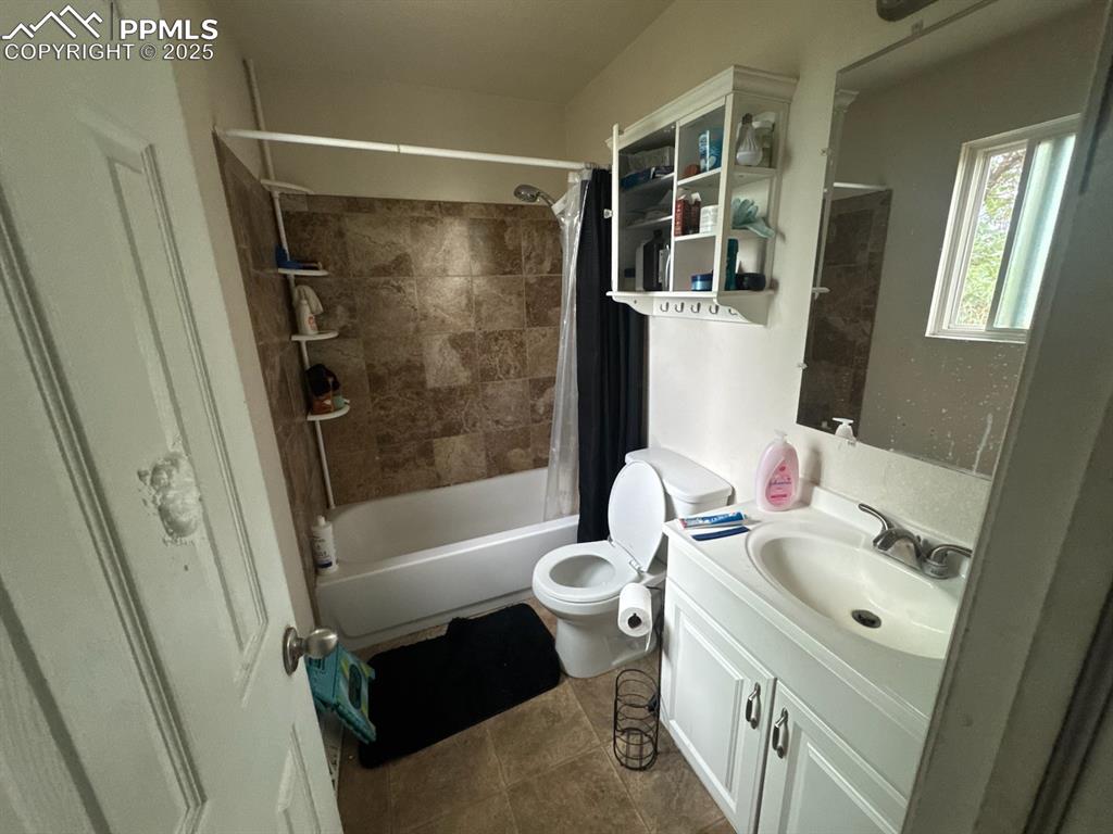Image 6 of 6: Bathroom with shower / bathtub combination with curtain and vanity