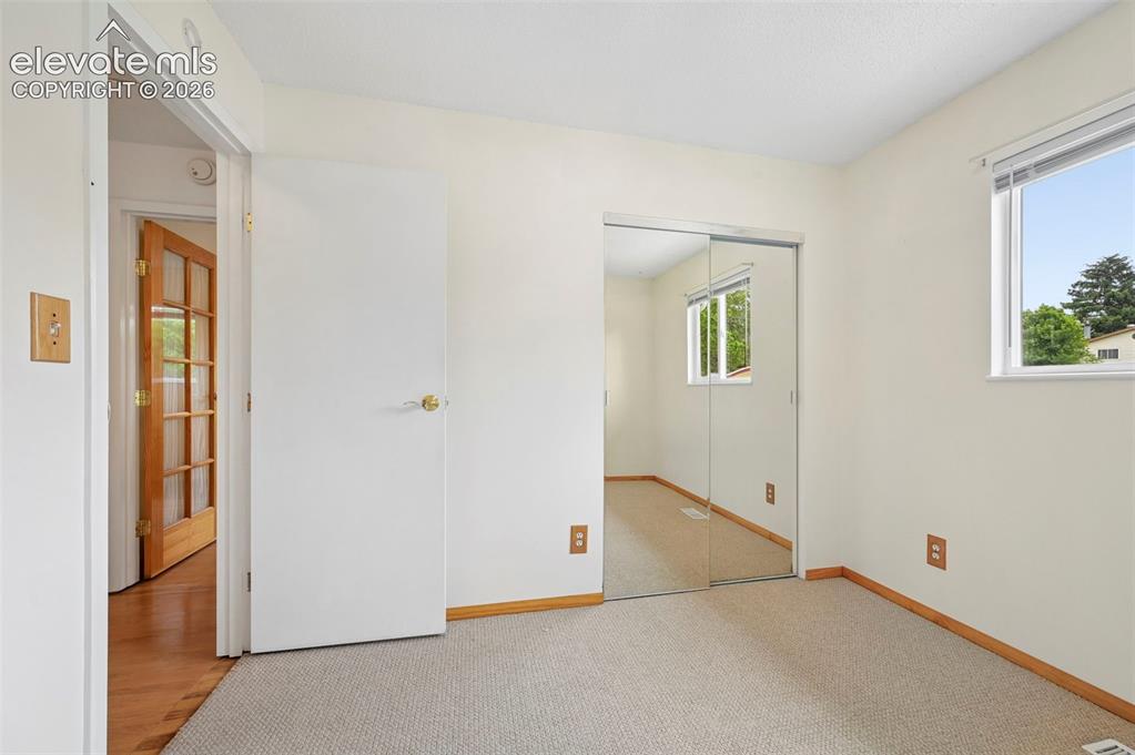 Image 19 of 50: Carpeted room featuring a window with exterior visibility, light-toned wall