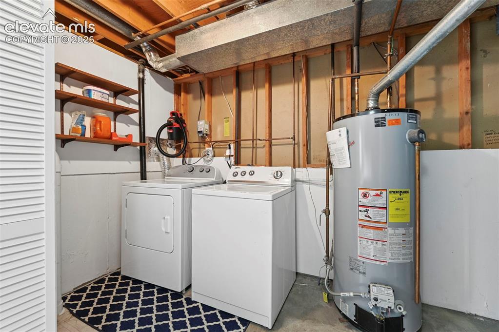 Image 28 of 50: Dedicated laundry area featuring a top-load washing machine, front-load dry