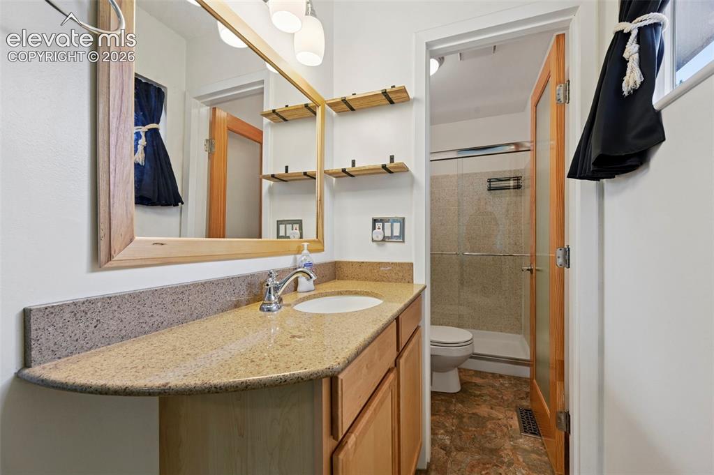Image 29 of 50: Bathroom vanity featuring a light-toned countertop, integrated sink, and wo