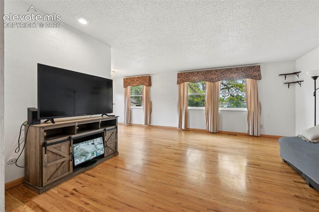 Image 33 of 50: Spacious interior featuring wood-finish flooring, recessed lighting, and mu