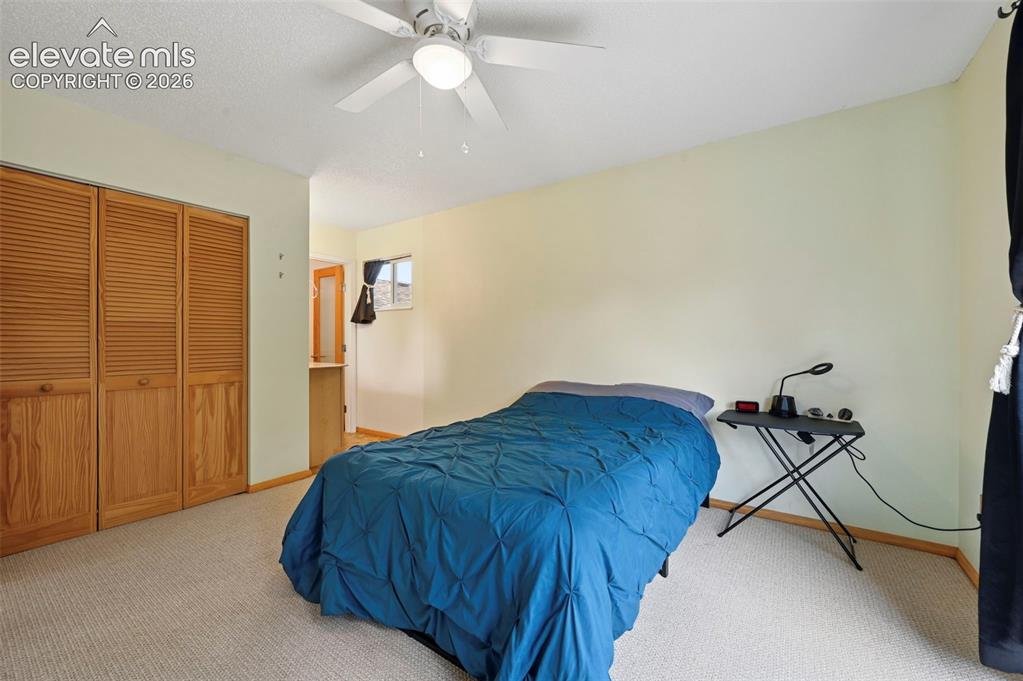 Image 40 of 50: Carpeted room featuring a ceiling fan with integrated lighting, louvered bi