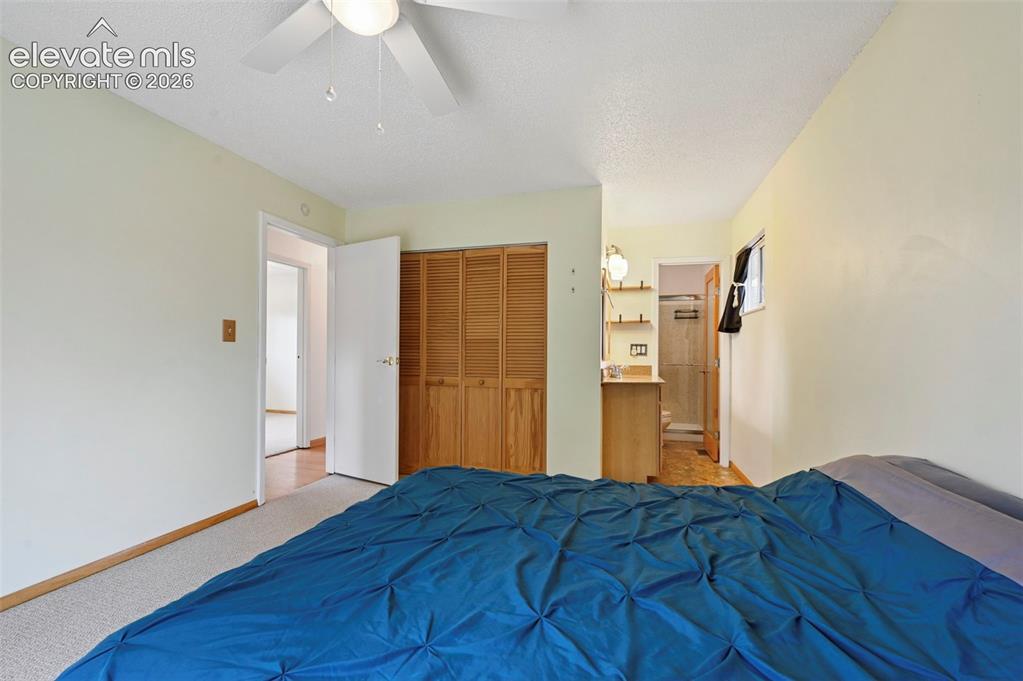 Image 41 of 50: Bedroom featuring light-colored walls, ceiling fan, and carpeted flooring