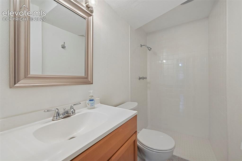 Image 44 of 50: Bathroom featuring a wood-finish vanity with an integrated sink and chrome