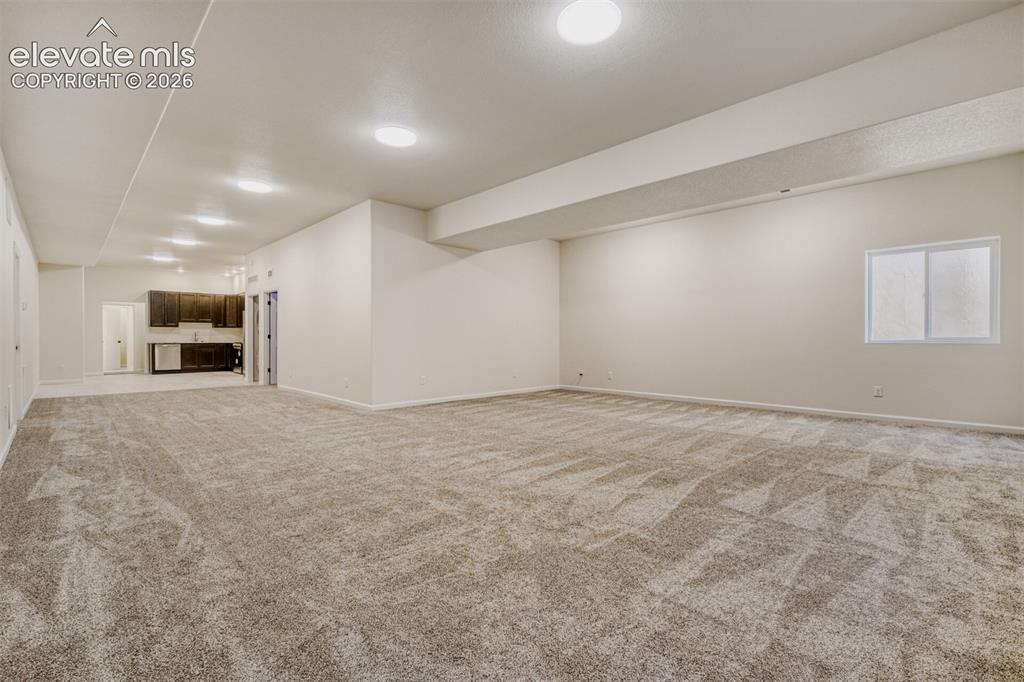 Image 32 of 50: Basement family/game room with kitchenette and second laundry