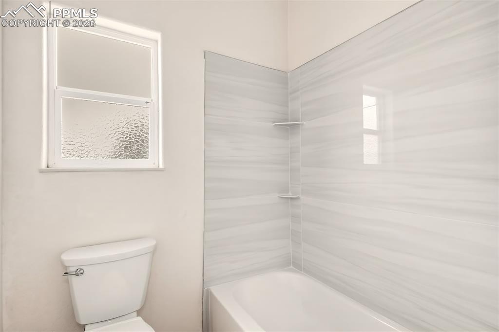 Image 16 of 35: Bathroom featuring toilet and shower / bath combination