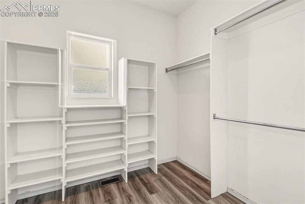 Image 24 of 35: Walk in closet featuring dark wood finished floors
