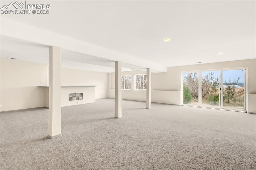 Image 30 of 35: Below grade area with light colored carpet and recessed lighting
