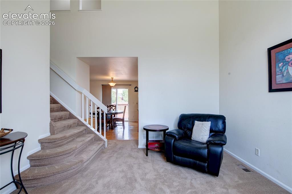 Image 10 of 34: Carpeted entryway with a curved staircase featuring white railings