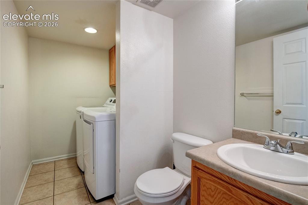 Image 13 of 34: Functional utility area featuring a toilet, a single vanity with a laminate