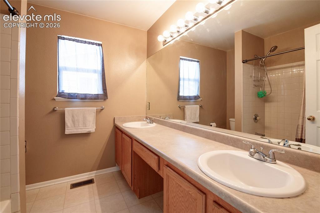 Image 17 of 34: Double vanity featuring two oval sinks with chrome faucets, set in a light-