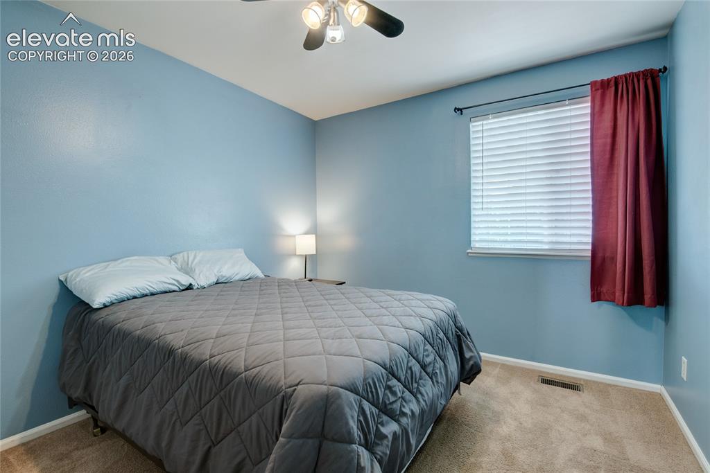 Image 19 of 34: Carpeted room featuring a ceiling fan with integrated lighting, a window wi