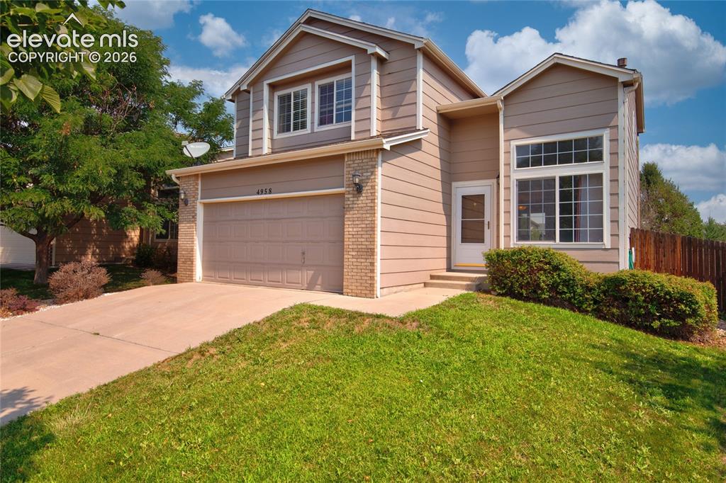 Image 2 of 34: Two-story property featuring a front-facing garage, brick accents, and a co