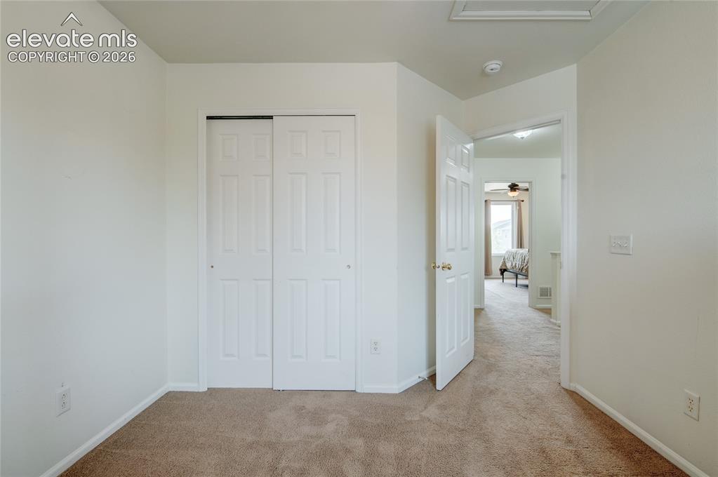 Image 20 of 34: Carpeted room featuring a white bi-fold closet and a classic white paneled 