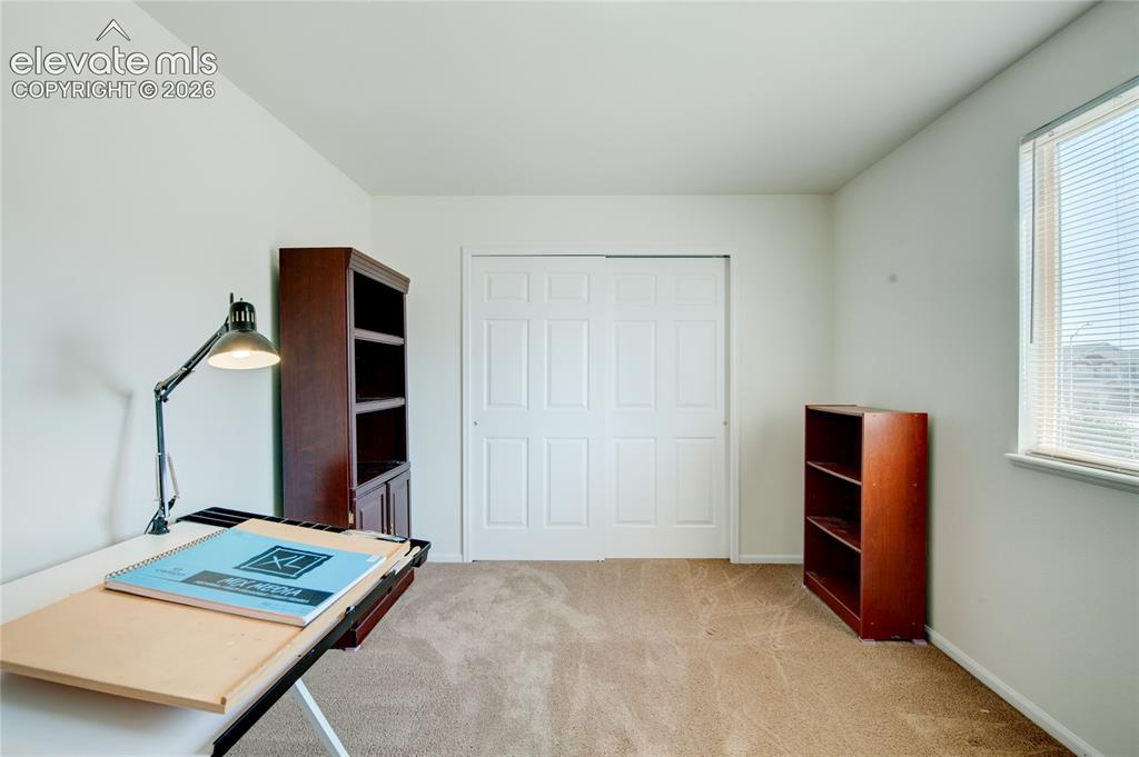 Image 22 of 34: Carpeted room featuring a double-door closet with paneled doors, a window w