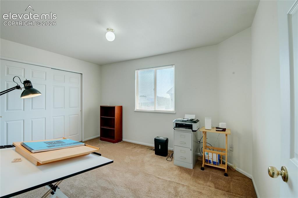 Image 23 of 34: Interior room featuring neutral wall paint, light brown carpet, and a windo