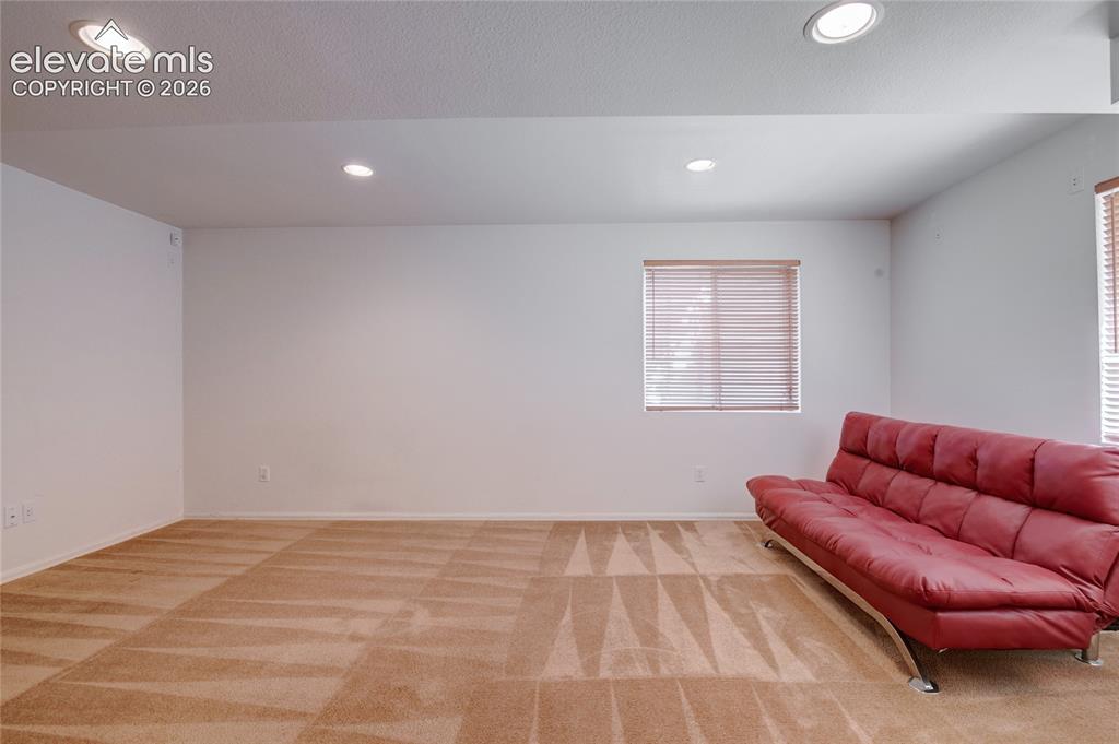 Image 26 of 34: Spacious room featuring neutral carpeting with a patterned design, recessed