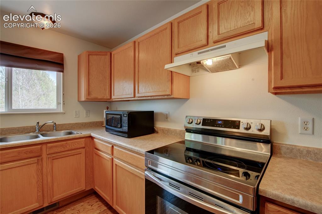 Image 3 of 34: Kitchen featuring light wood cabinetry, a double basin stainless steel sink