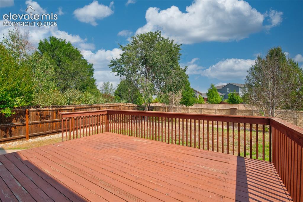 Image 31 of 34: Spacious outdoor deck with wood railing, offering an open-air area for ente