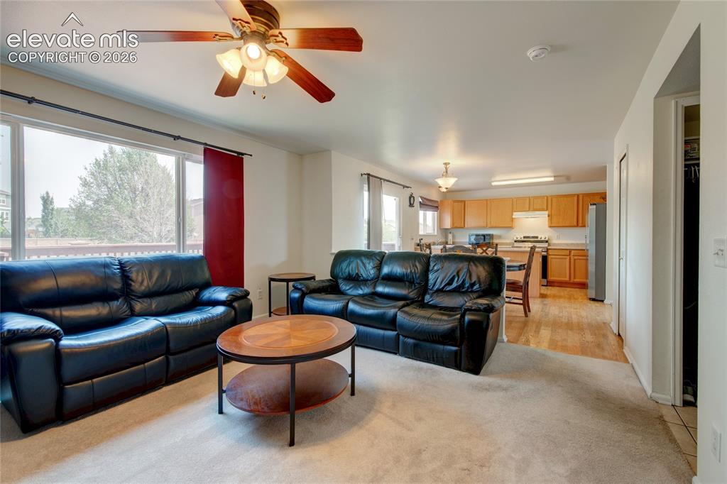 Image 9 of 34: Open-concept living area featuring a large window, a ceiling fan with integ
