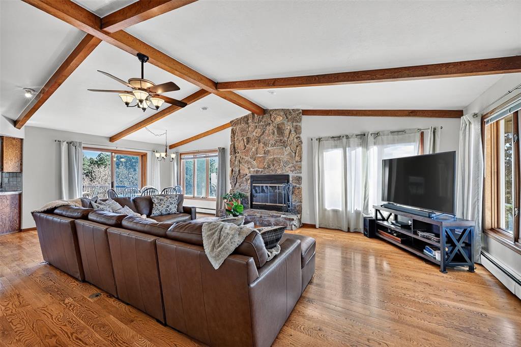 Image 10 of 48: Another view of the main level family room with beamed ceiling, stone firep