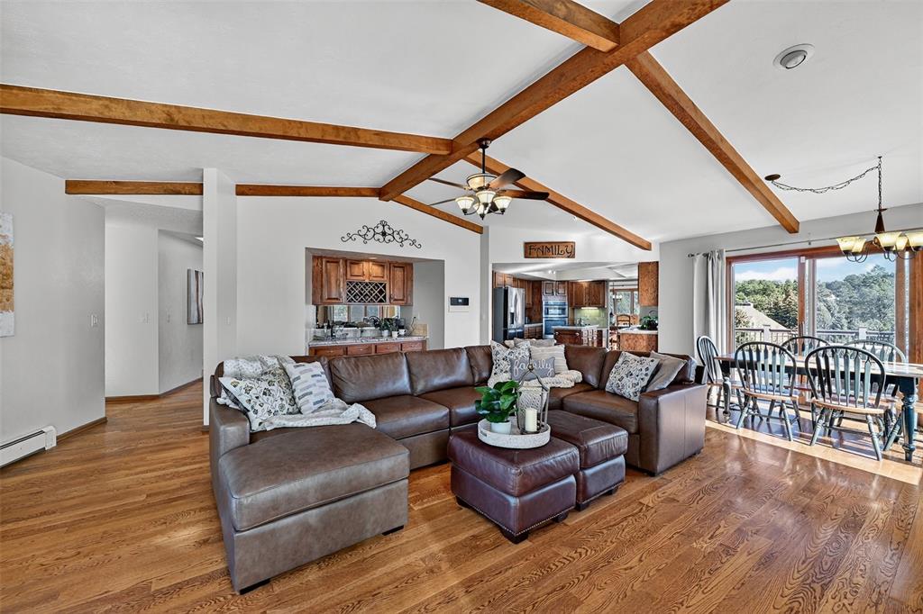 Image 12 of 48: Huge living room with beamed ceiling opens to the kitchen and wet bar!