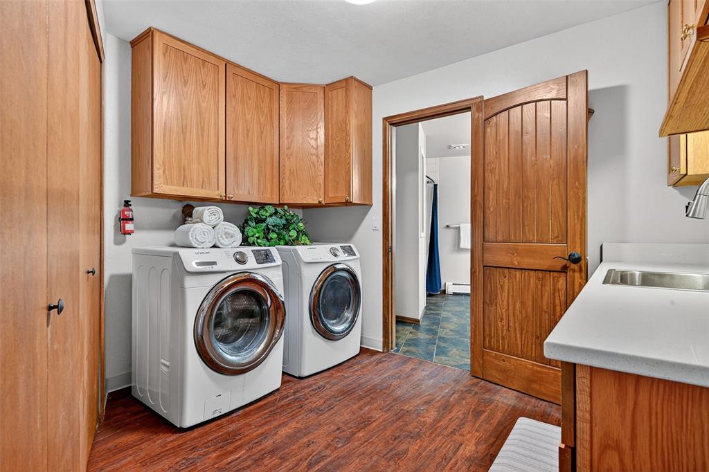 Image 33 of 48: Huge laundry room with upper and lower cabinets, sink and folding counters!