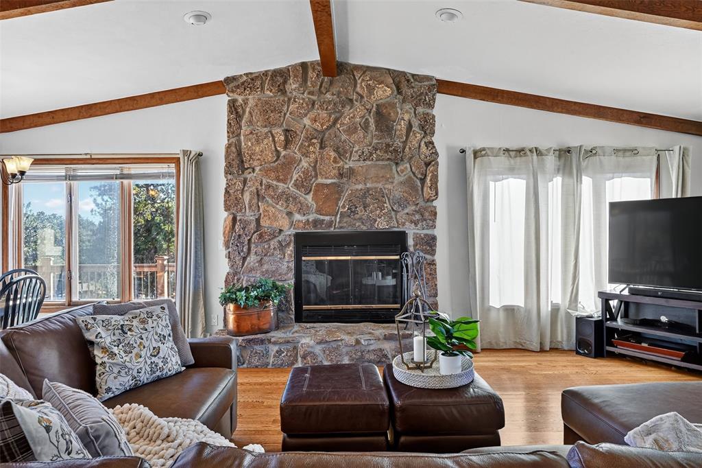 Image 9 of 48: Wow!  Beautiful full height stone fireplace and beamed ceiling!  